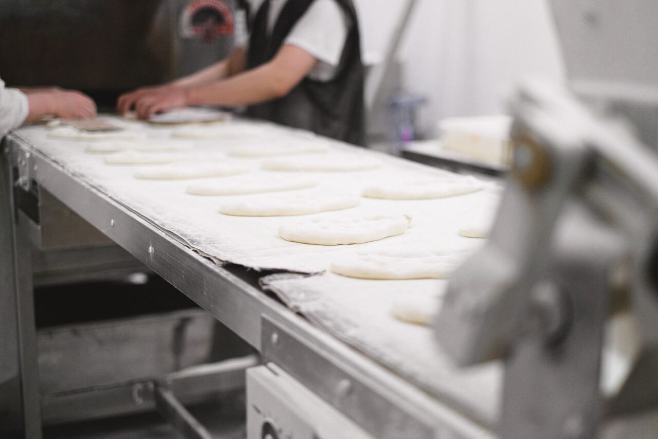 How Can a Business Reduce Operating Costs Without Damaging Value? 1 Bakery production team improving workflow to reduce operating costs