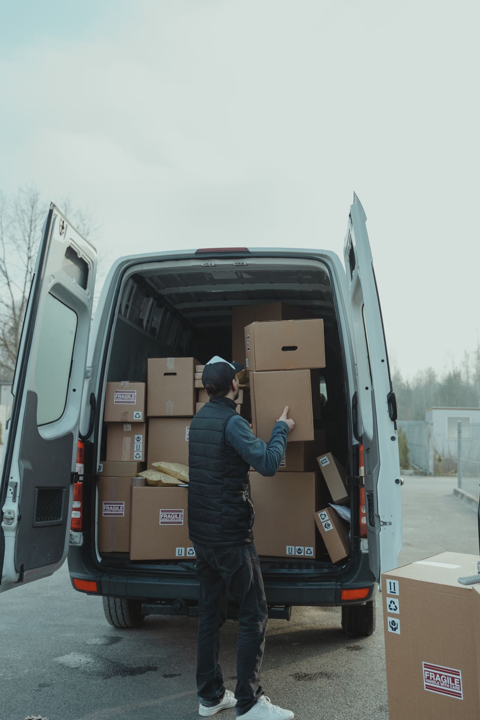 How Can a Business Reduce Operating Costs Without Damaging Value? 4 Delivery worker loading a van as part of an efficient logistics process