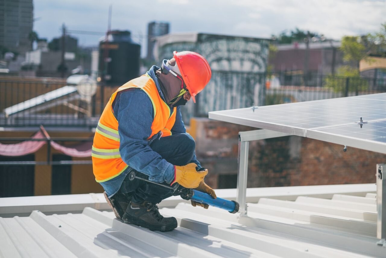 How Can a Business Reduce Operating Costs Without Damaging Value? 3 Technician installing energy-efficient equipment on a commercial roof